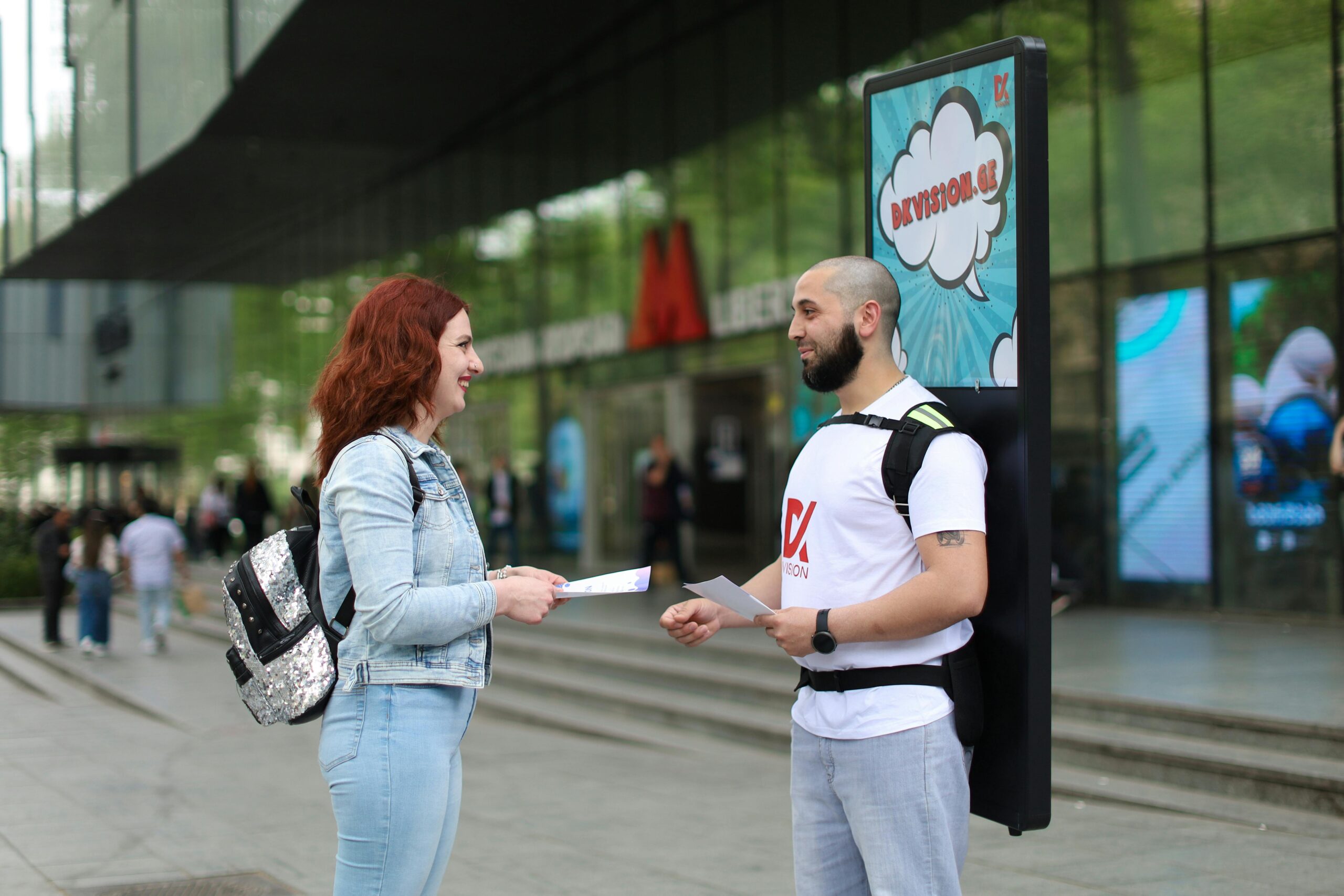 A man with flyers promoting brand awareness to a customer